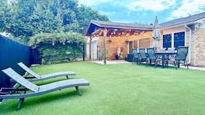 Lovely patio and backyard with lounge chairs perfect for sunbathing.