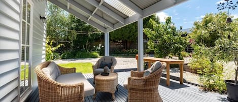 Relax on the deck while enjoying the beautiful surrounding gardens