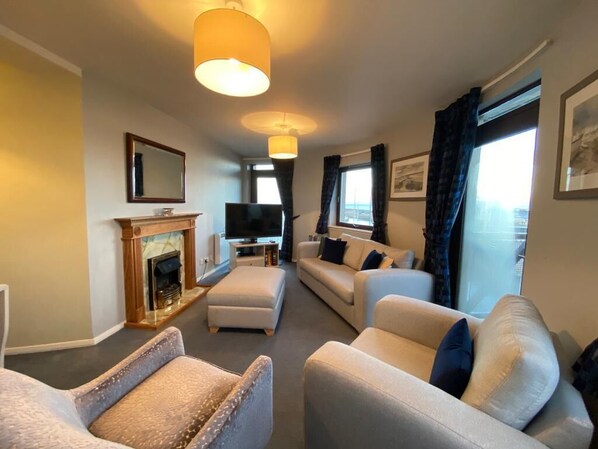 Living Room with flat screen, smart TV, door access for two small balconies. 