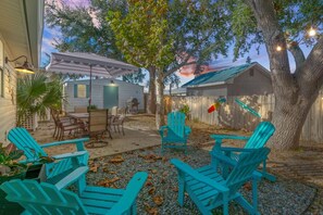 Enjoy a peaceful sunset in the backyard with a cozy seating area, picnic table, and the perfect shade of trees.