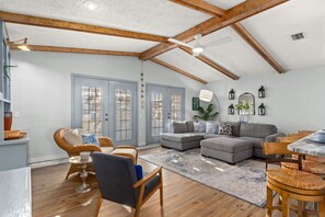 The living room is beautifully illuminated by natural light streaming through elegant French doors.