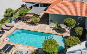 The pool features a shallow lounge area, benches and a deeper part