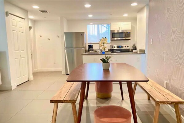 Dining room and equipped kitchen at the back. Laundry room's door to the left. 