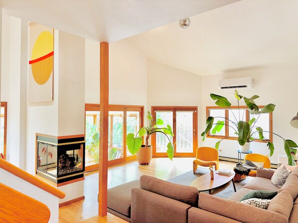 Main living room area filled with natural light connected to outdoor spaces. 