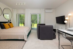 A bedroom with a bed and a gray sofa placed near the window, creating a cozy space.