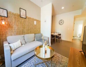 Living Room with pullout couch and Smart TV. Dining area and bedroom to the back