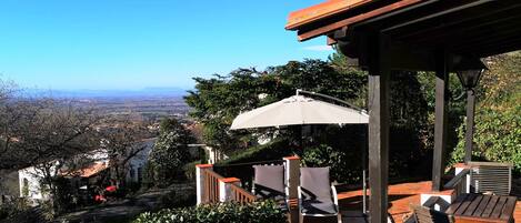 Überdachte Veranda und Terrasse mit Sonnenliegen und Schirm von Petit Charme