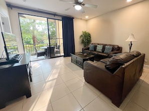 The living room has comfy furniture, a Smart TV and access to the covered terrace.  