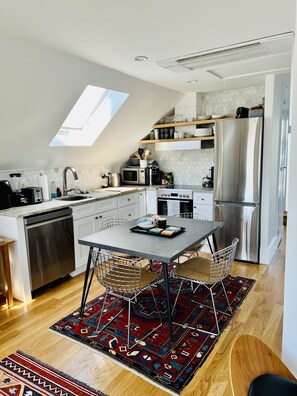 Fully stocked kitchen and dining area with dishwasher and electric range/stove. 