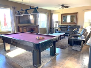 Pool table overlooking living room and 65" TV with Direct TV & Streaming.