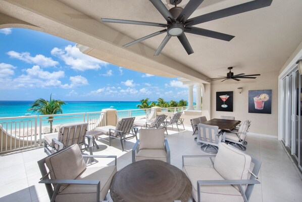 Furnished balcony with outdoor seating and tables.