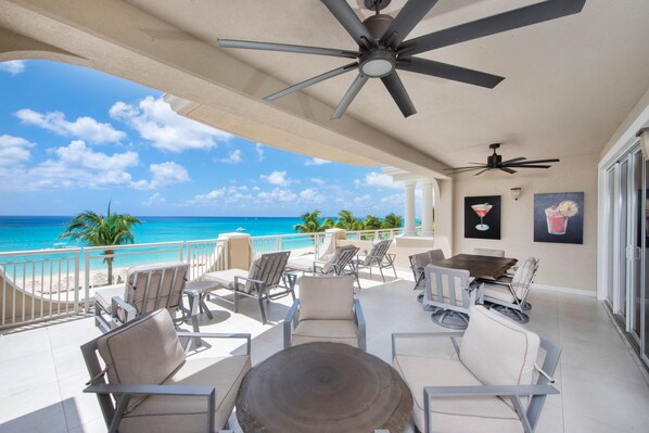 Furnished balcony with outdoor seating and tables.