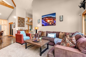 Living Room with plush furnishings, wood-burning fireplace, smart TV, and private deck access