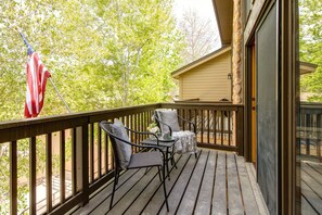 Living Room with plush furnishings, wood-burning fireplace, smart TV, and private deck access