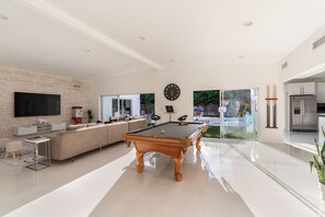 Modern open Concept Living room with pool table and beautiful view on the pool
