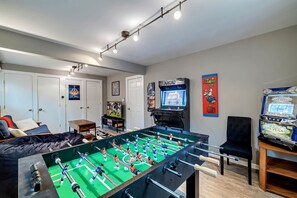 Pocono mountains rental | The game room is a fun-filled space with a foosball table, PS4, TV, darts, a skill slot machine, arcade games, and a variety of board games, perfect for entertainment and relaxation