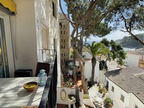This photo shows the private balcony of the apartment, with a table and chairs, perfect for enjoying a morning coffee or an evening glass of wine while taking in the stunning views of the surrounding village, the Mediterranean Sea, and the lush greenery. 
