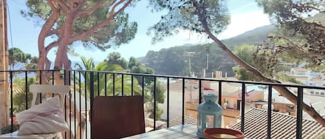 Enjoy a relaxing meal on the private balcony, with views of the sea and the charming town of Tamariu. The balcony features a white table and chairs, perfect for enjoying a morning coffee or an evening glass of wine.