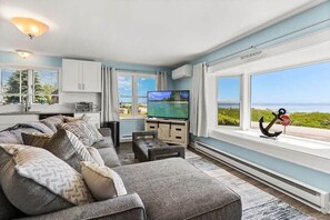 Living room with sleeper sofa, 50" smart TV, high-efficiency mini-split for AC/heat, and stunning views of the ocean.