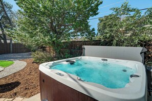 Enjoy a soak in the private hot tub, nestled in a serene backyard setting—perfect for unwinding after a day of exploring.