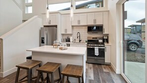 Open concept fully stocked kitchen and breakfast bar seating fro 3.