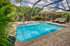 Heat pump heated saltwater pool surrounded by palms for a tropical setting.