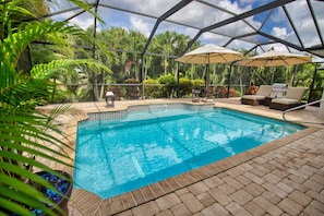 Heat pump heated saltwater pool surrounded by palms for a tropical setting.