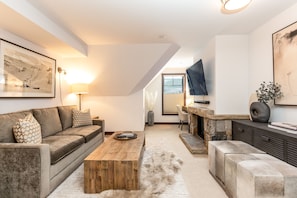 Living room with 65" smart tv, cable for watching sports and gas fireplace.