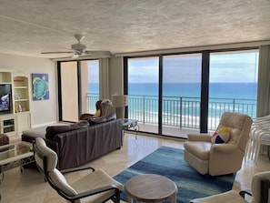 Living room + sitting area with floor to ceiling sliders.