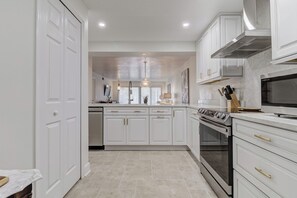 Kitchen area designed for both cooking and gathering, featuring modern appliances, ample counter space, and cookware.