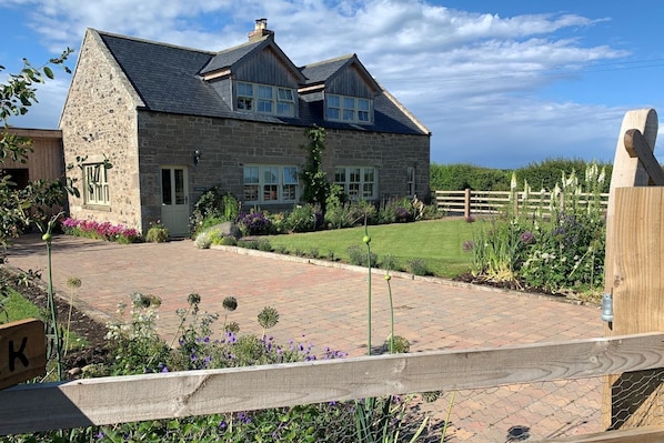 Goose Cottage - pretty cottage exterior with beautiful garden and blue skies