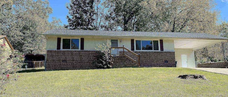 Large front yard with two car carport.