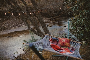 Unwind in our cozy hammock by the creek, where the gentle sounds of the water create the ultimate relaxation spot. 🌿💧