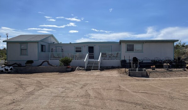 Front view of entire house. BBQ and fire pit off to the right in fenced area. 