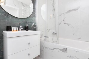 The bathroom's contemporary design includes fresh towels and a hairdryer.