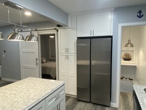 Kitchen with view of bedroom entrance. 