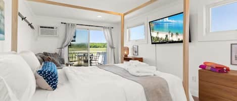 Bedroom with queen bed, sleeper sofa, work desk, smart TV and slider to private back deck