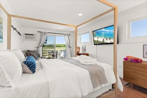 Bedroom with queen bed, sleeper sofa, work desk, smart TV and slider to private back deck