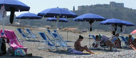 Esterno dell'edificio. Spiaggia con ombrelloni e sdraio in estate