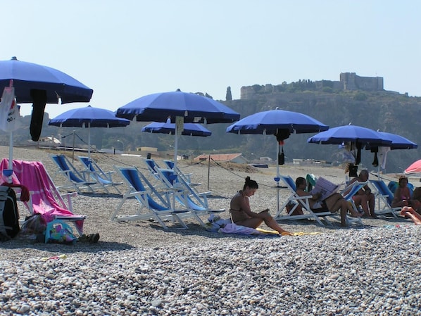 Esterno dell'edificio. Spiaggia con ombrelloni e sdraio in estate