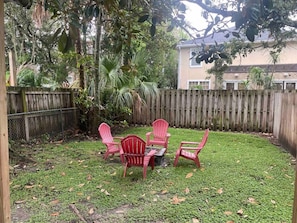 Welcome to your private oasis in Jacksonville Beach! Step into our fenced-in outside yard, where coastal serenity meets warmth.  Gather around the inviting fire pit.