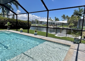 Enjoy the view of the canal from the comfort of the pool's sun shelf.