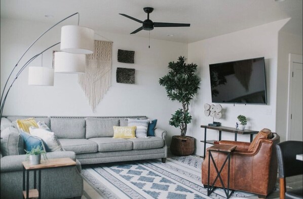 Main living area open to the kitchen with a 65" TV.