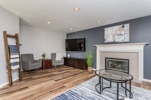 Large living room with gas fireplace and additional seating area. Smart TV