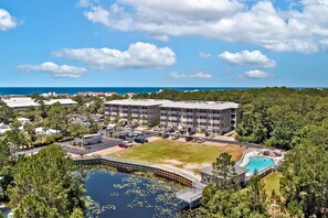 Areal view of complex, pool, and pond.