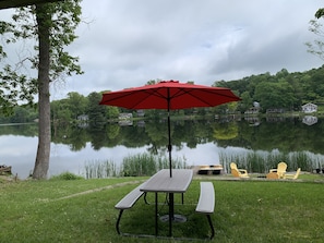 Upper tier of back yard with picnic table and 9’ patio umbrella