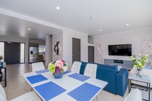 Living room area with sofa, sofa-bed and 6-seat dining table.