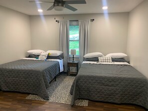 Large second bedroom with two queen beds, dresser and SmartTV