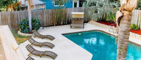Outdoor saltwater pool has plenty of seating to soak up the sun