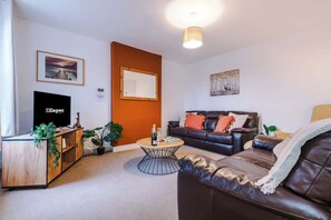 The spacious living space benefits from 2 sofas, a 40-inch smart TV and plenty of space to sit down and relax.